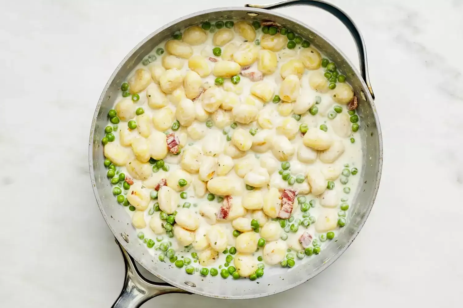 Gnocchi cremoso con tocino y guisantes